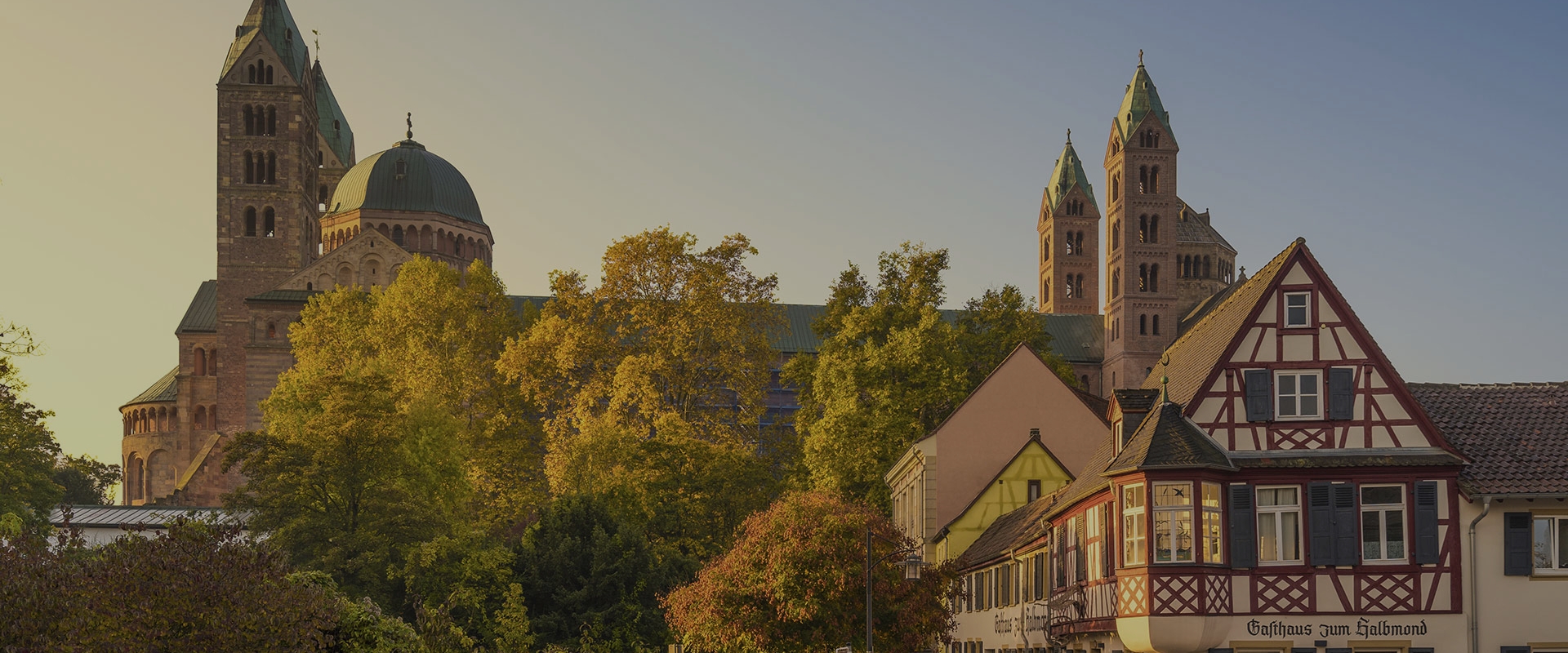 Blick auf den Speyerer Dom in der Abendsonne mit Fachwerkhaus im Vordergrund