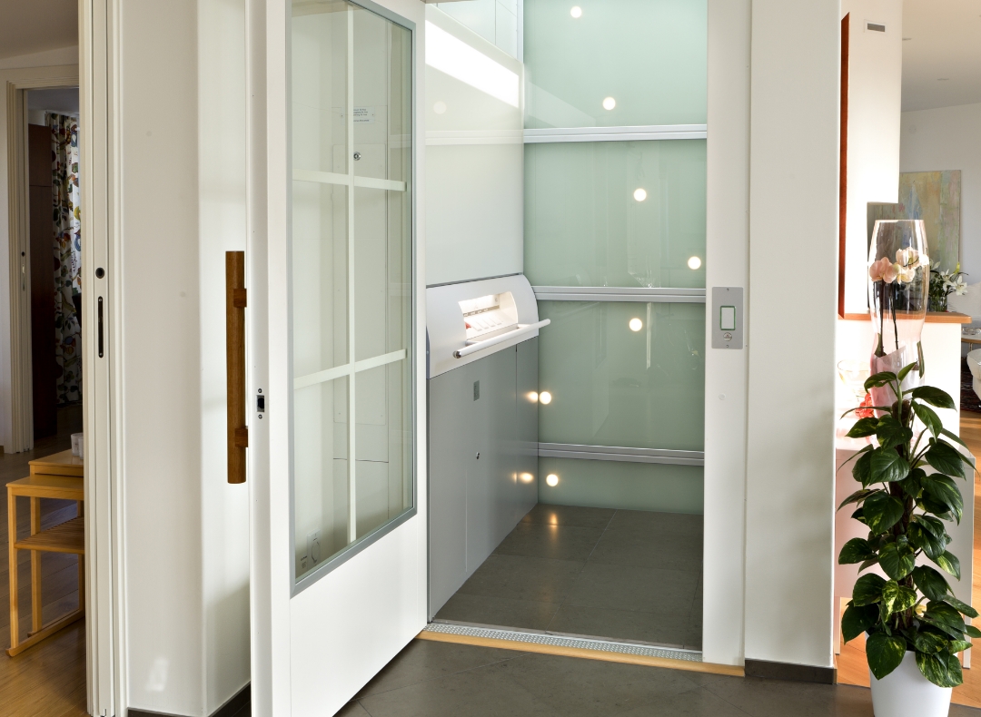 Blick in einen Lift mit offener Tür mitten in einem Wohnzimmer